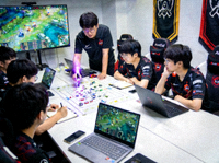 青训战队日常训练场景，教练指导选手进行战术复盘